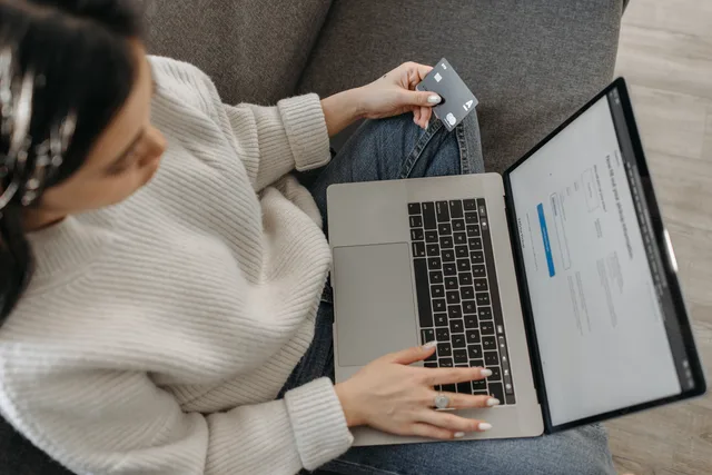 Young woman shopping online using her laptop and credit card from home. Ecommerce platforms market entry checklist for England